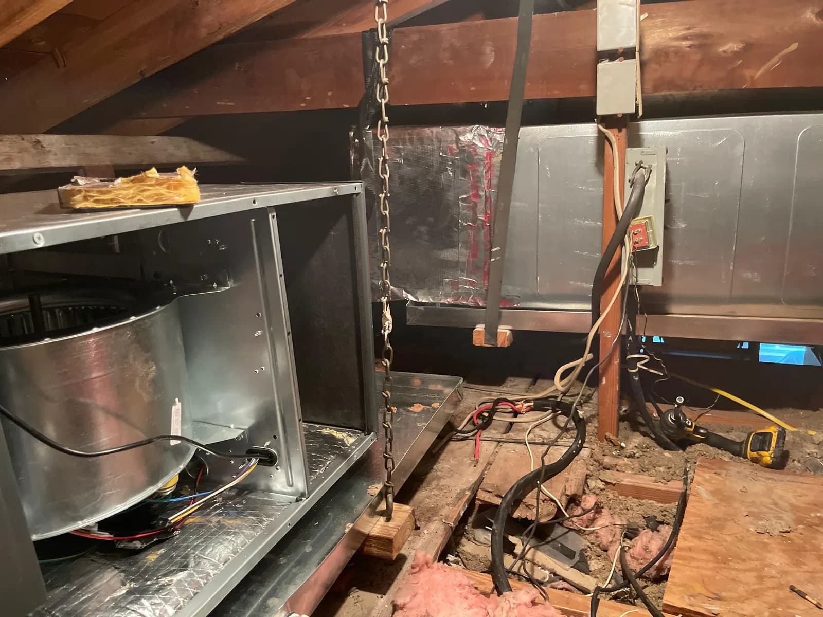 Air handler replacement in progress in a Florida attic, with old ductwork and blower assembly visible