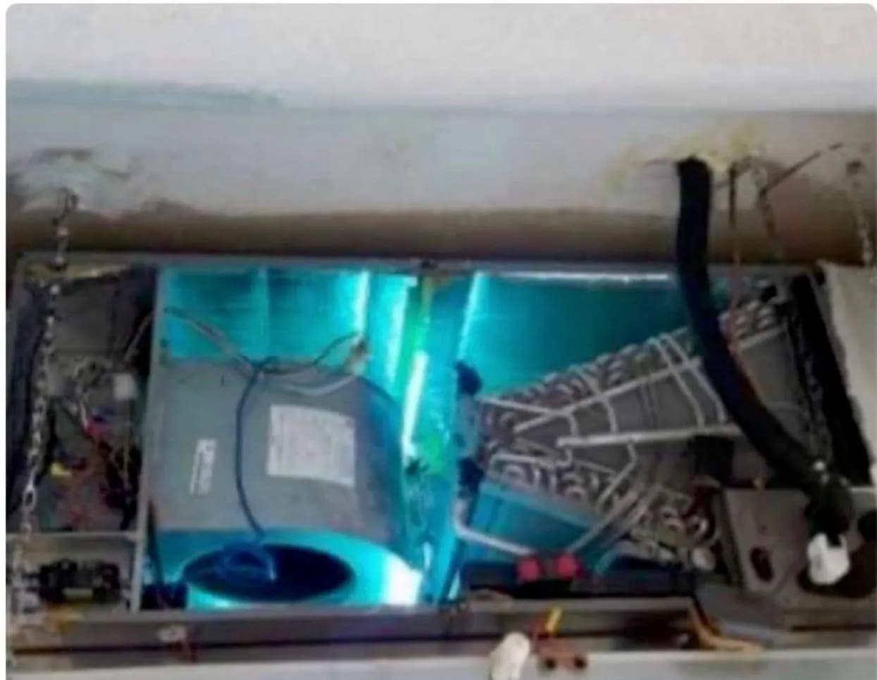UV-C germicidal lamp illuminated inside an air handler cabinet above the evaporator coil