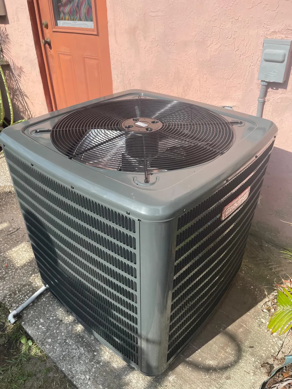Newly installed Goodman outdoor condensing unit on a concrete pad beside a stucco home in Orlando